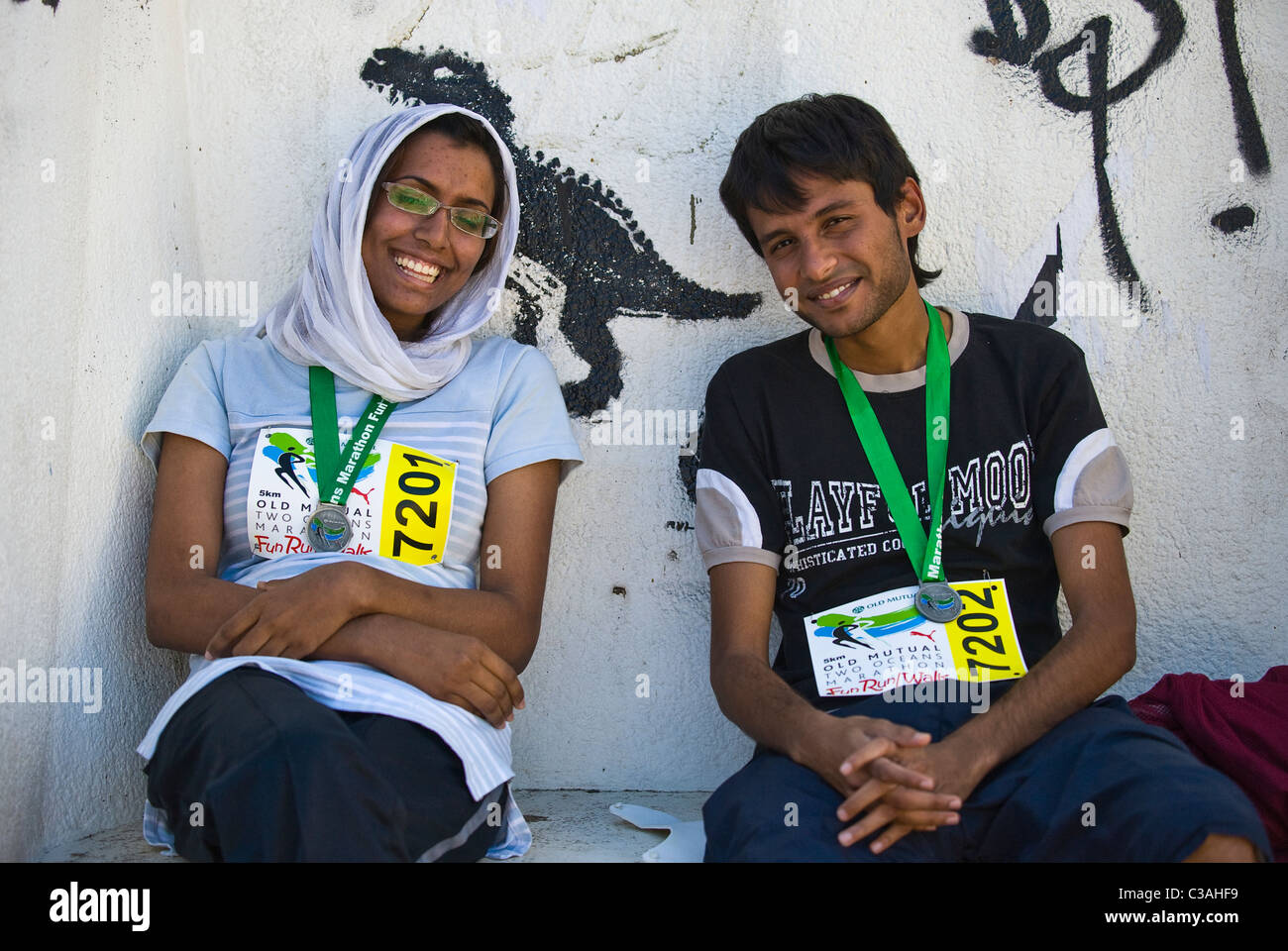 Guide di scorrimento con medaglie riposo dopo il 5km Fun Run di due oceani maratona, Cape Town, Sud Africa Foto Stock