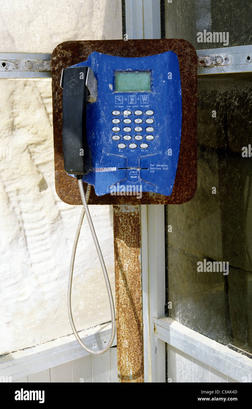 Weathered MALTACOM telefono pubblico a Dwejra Point sull'isola Maltese di Gozo. Foto Stock