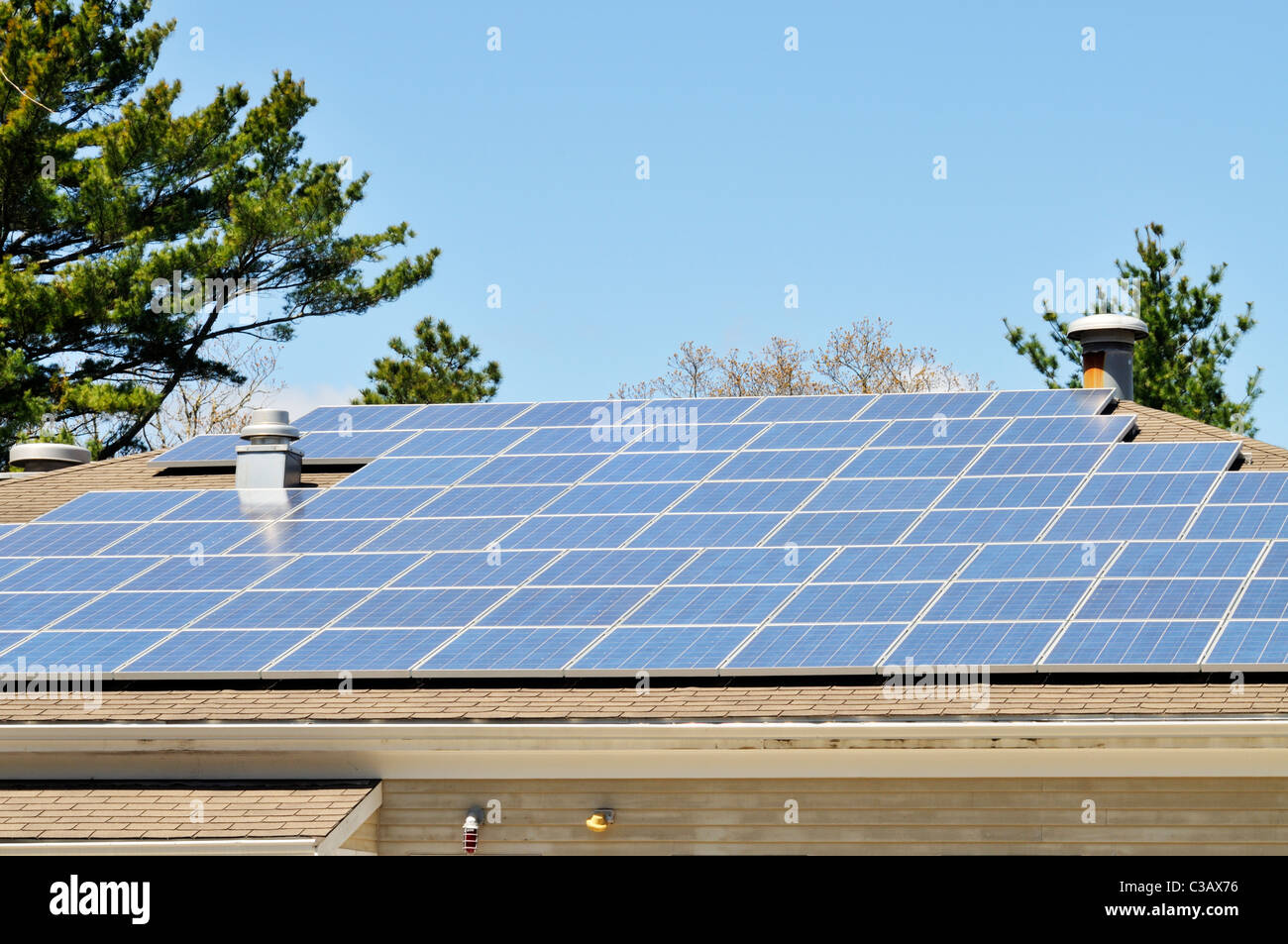 Pannelli solari sul tetto di un edificio su un soleggiato blue sky giorno Foto Stock