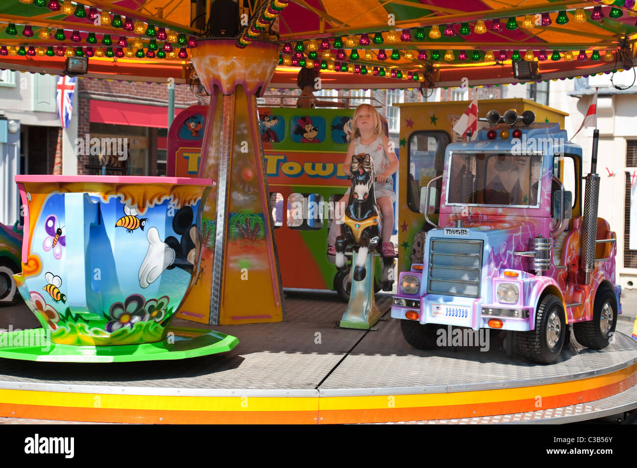 Un giovane bambino a cavallo di una giostra Merry Go Round, Wallingford, Oxfordshire, Regno Unito Foto Stock