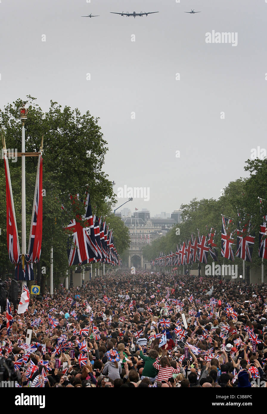 La folla si raccolgono sul Mall come la RAF eseguire un fly-passato di Buckingham Palace dopo le nozze del principe William e Kate Foto Stock