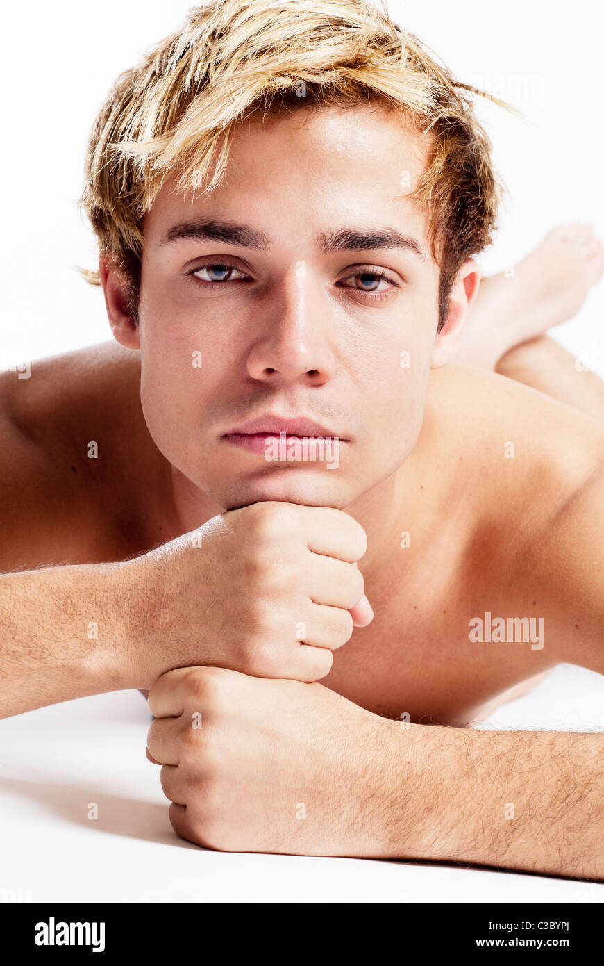 Giovane uomo disteso con le mani sul mento in biancheria intima Foto Stock