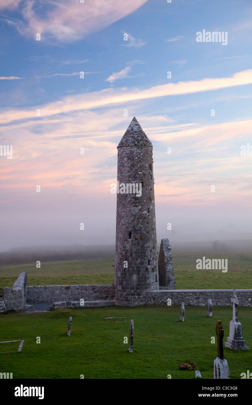 Dawn mist intorno al tempio e Finghin round tower, Monastero di Clonmacnoise, nella contea di Offaly, Irlanda. Foto Stock