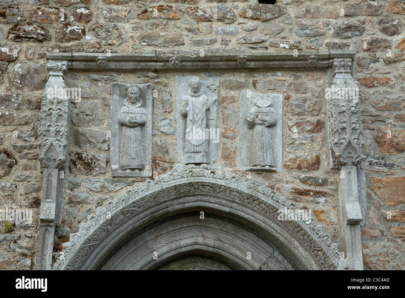 Sculture in pietra dei santi oltre la porta nord di Clonmacnoise cattedrale, nella contea di Offaly, Irlanda. Foto Stock