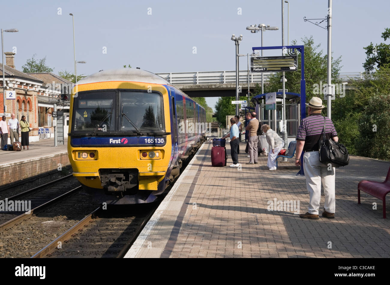 Primo grande Western treno di Gatwick si avvicina la stazione ferroviaria con i passeggeri in attesa sulla piattaforma. Nord Camp, Inghilterra, Regno Unito, Gran Bretagna Foto Stock