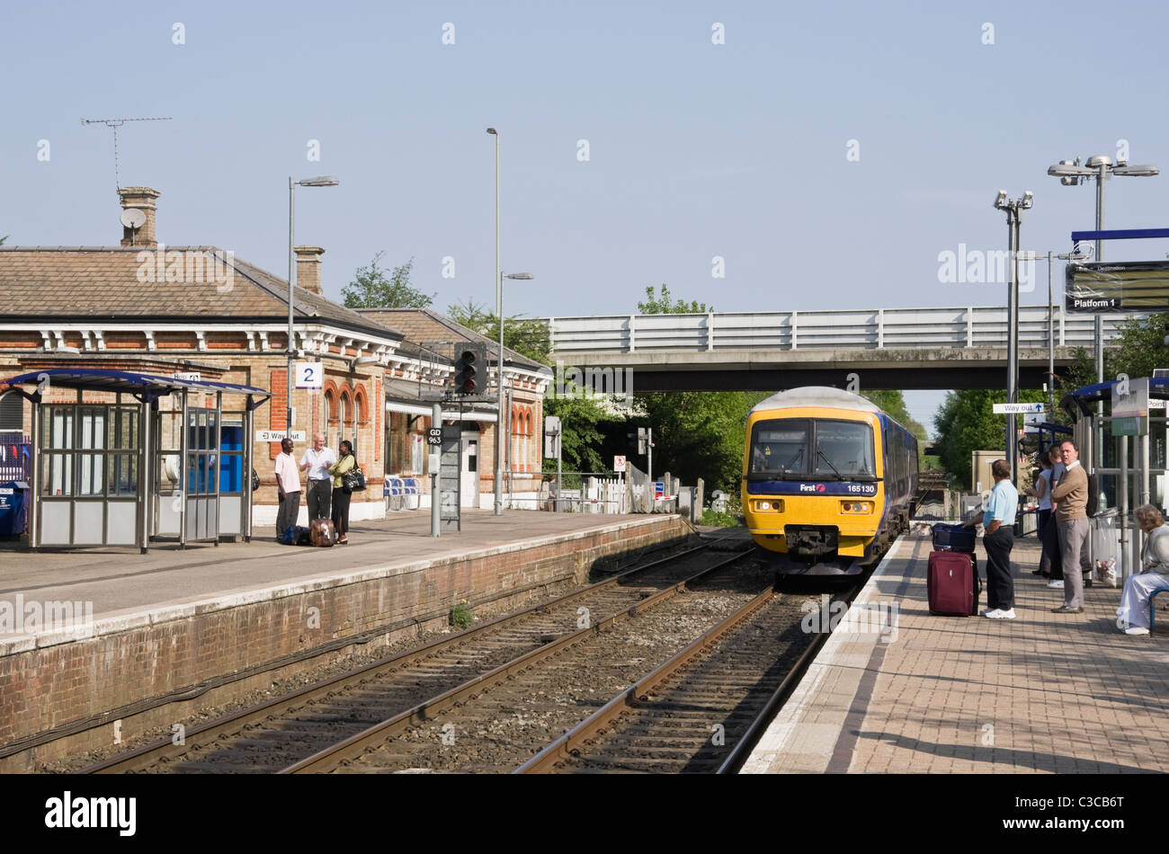 Nord Camp, Hampshire, Inghilterra, Regno Unito. Primo grande Western Treno in avvicinamento alla stazione ferroviaria con i passeggeri in attesa sulla piattaforma Foto Stock