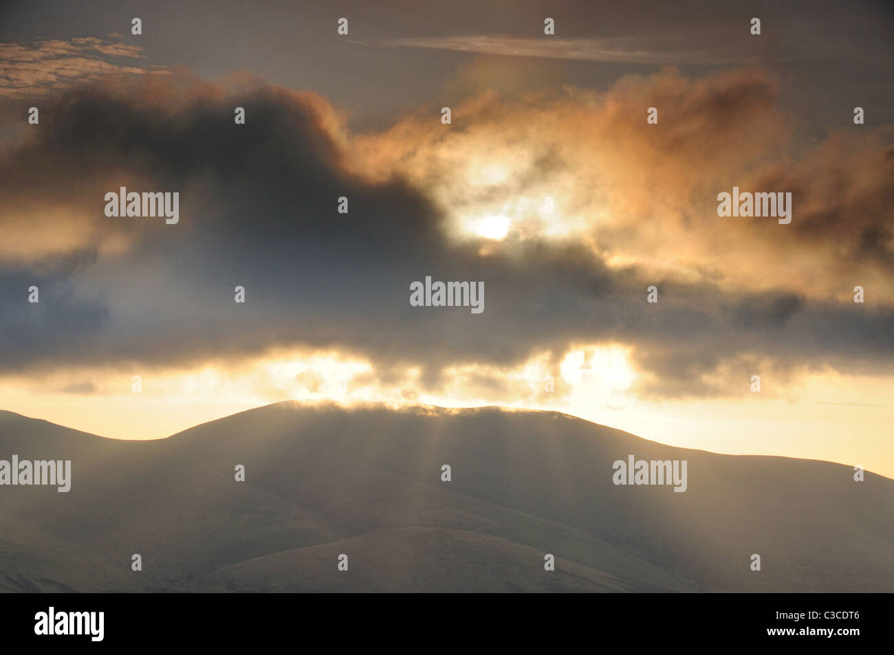 Raggi di sole da dietro il cloud su Skiddaw nel Lake District inglese Foto Stock