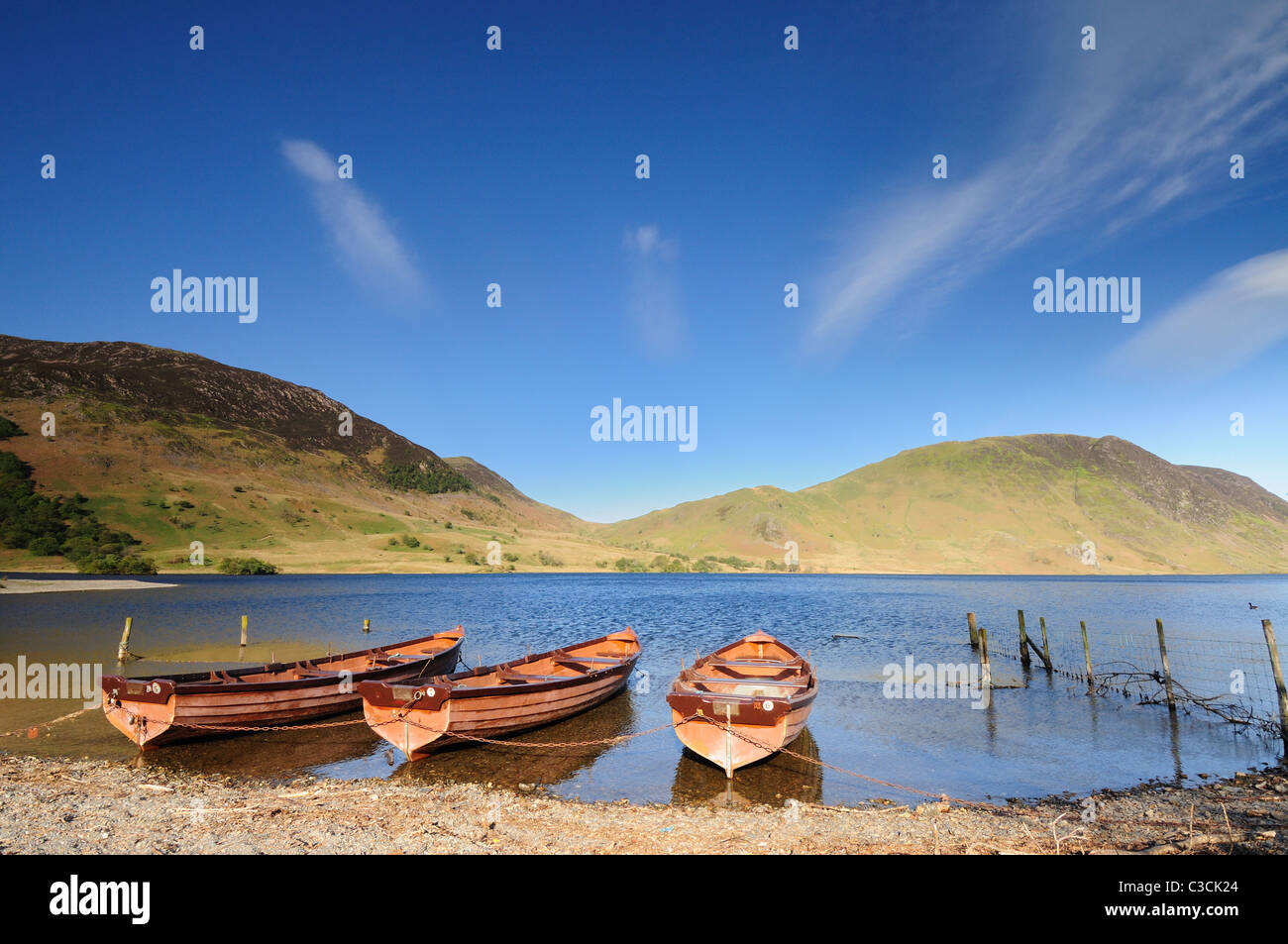Barche a remi in acqua Crummock nel Lake District inglese, con Mellbreak in background Foto Stock