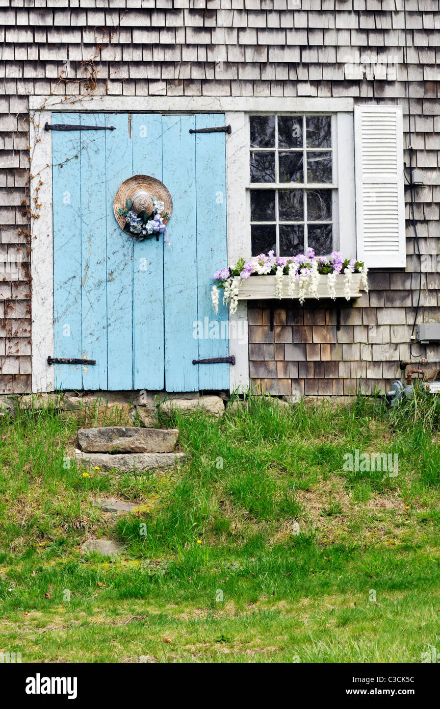 Il pittoresco Cape Cod fienile con fioritura window box e decorate cappello di paglia sulla porta. Stati Uniti d'America Foto Stock