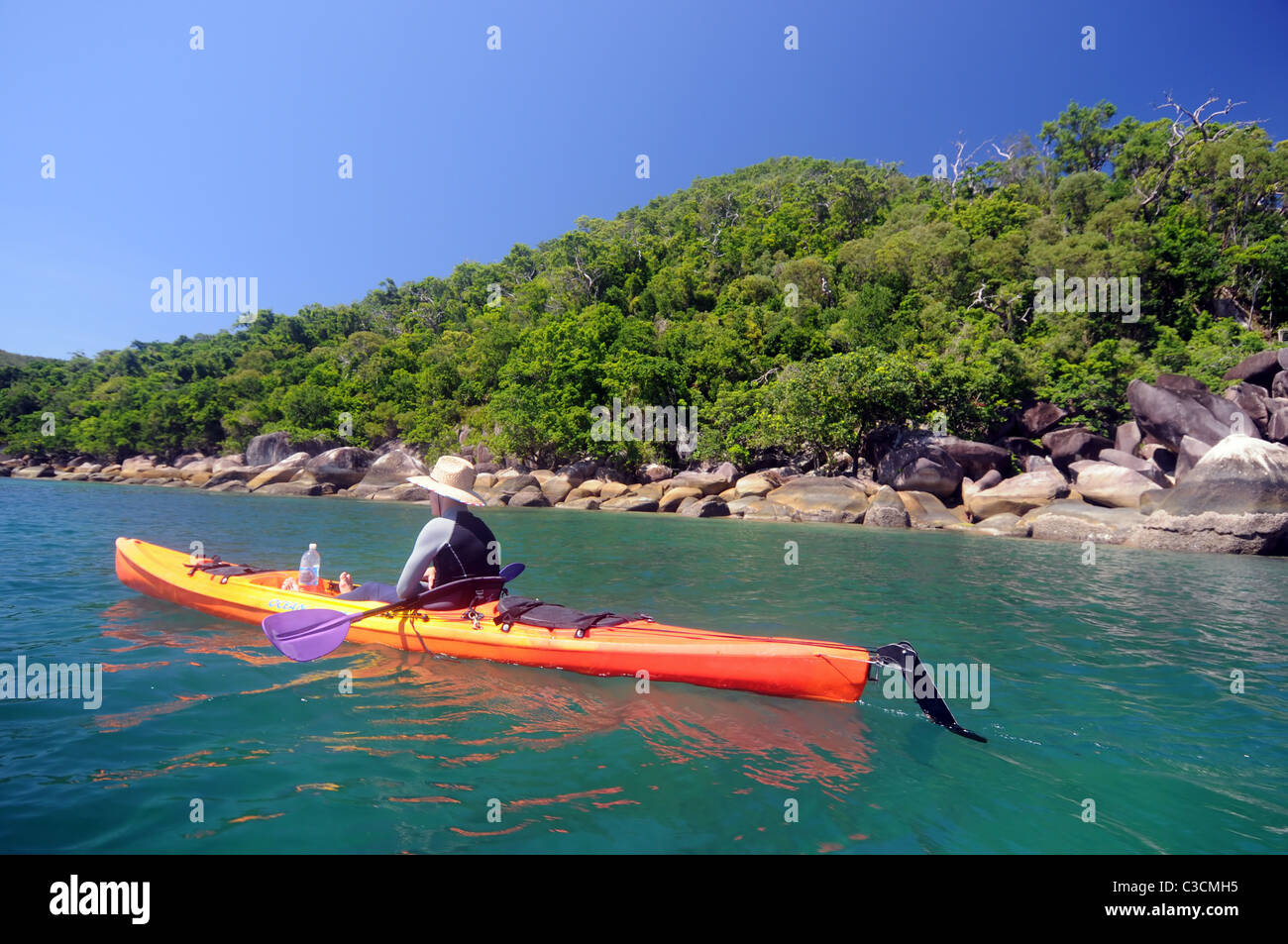 Kayaker passando l'Isola Fitzroy, della Grande Barriera Corallina, Queensland, Australia. No signor o PR Foto Stock