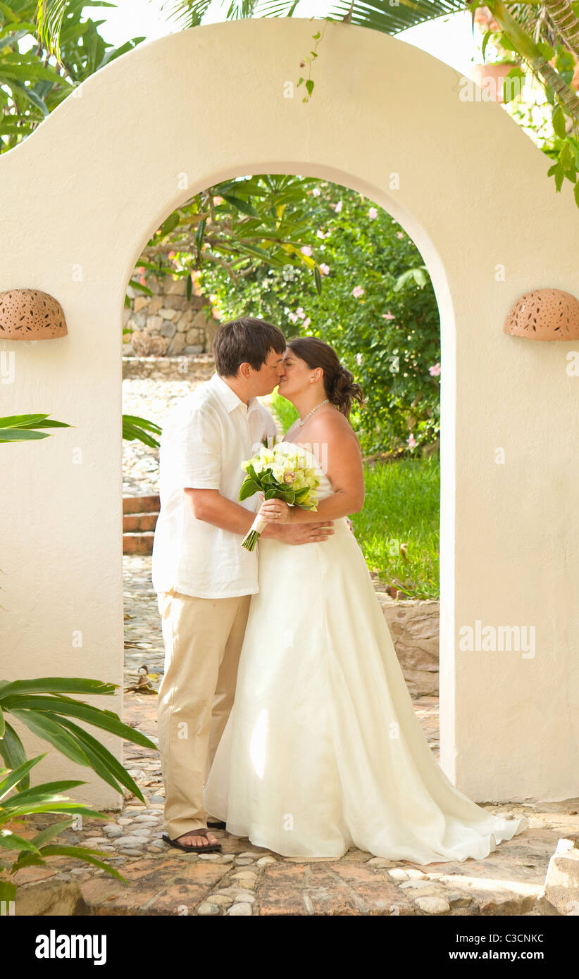 Coppia di sposi kissing all'aperto Foto Stock