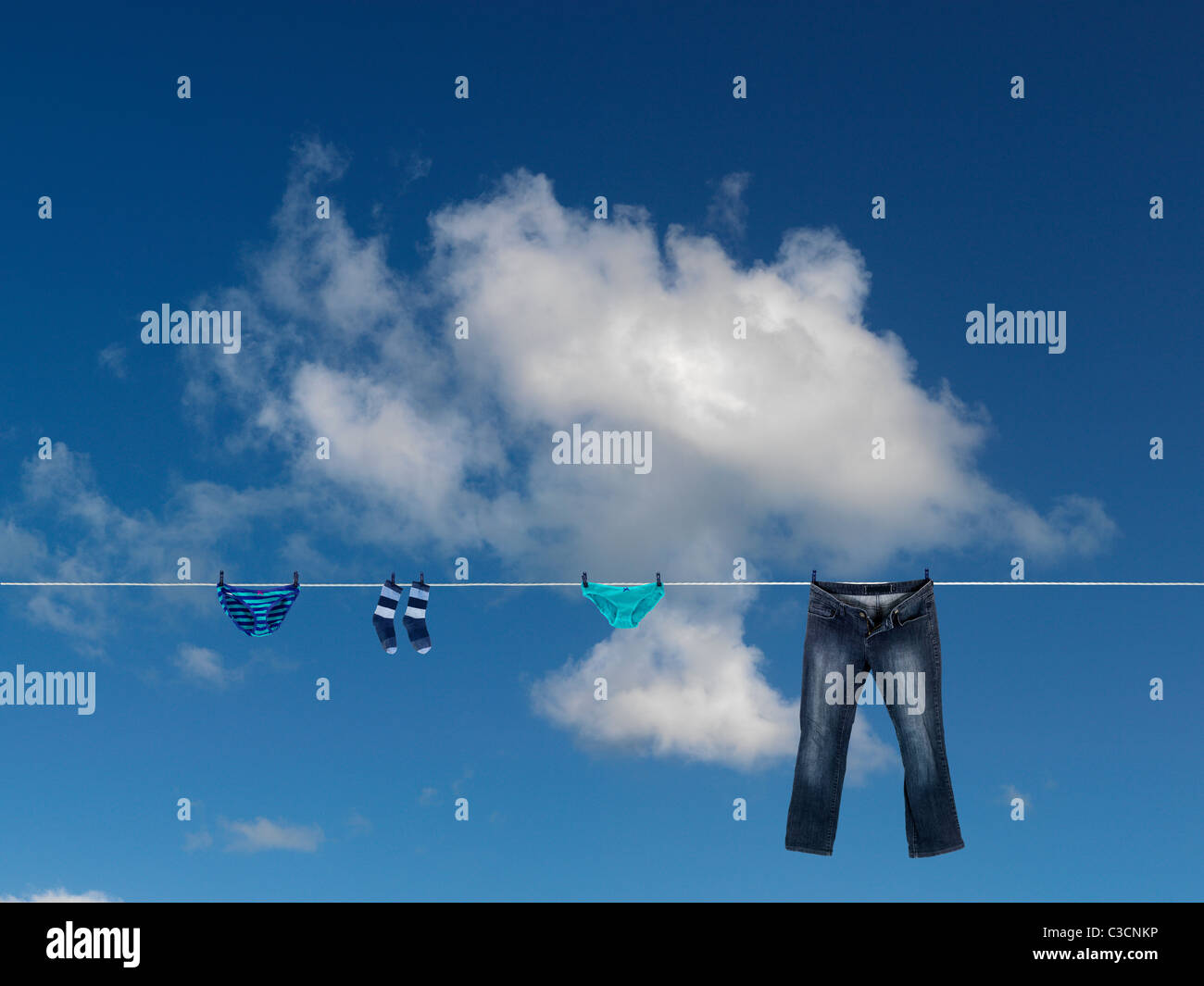 I vestiti su una linea di abbigliamento isolata contro un cielo blu Foto Stock
