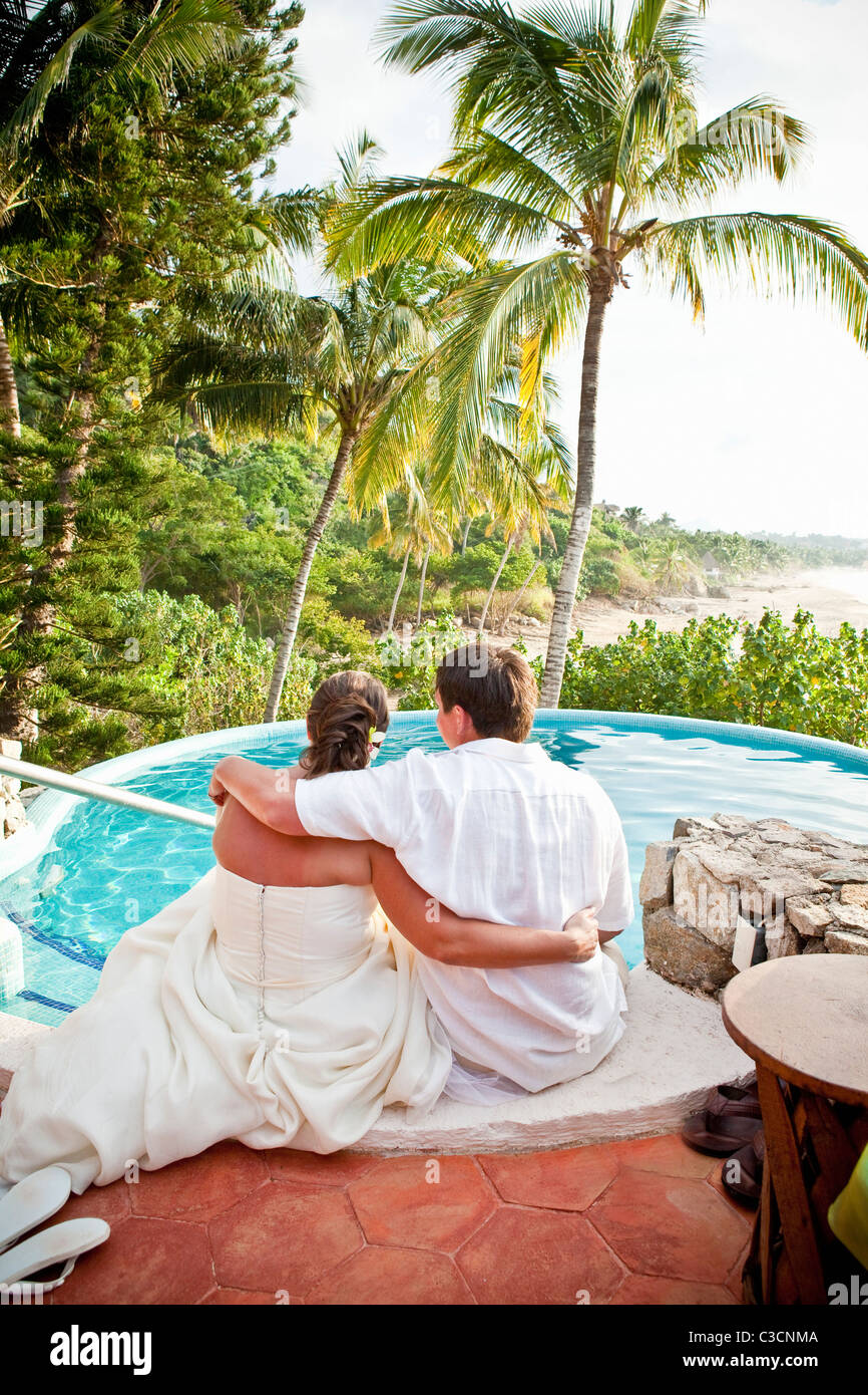 Coppia di sposi seduto con i piedi in piscina Foto Stock