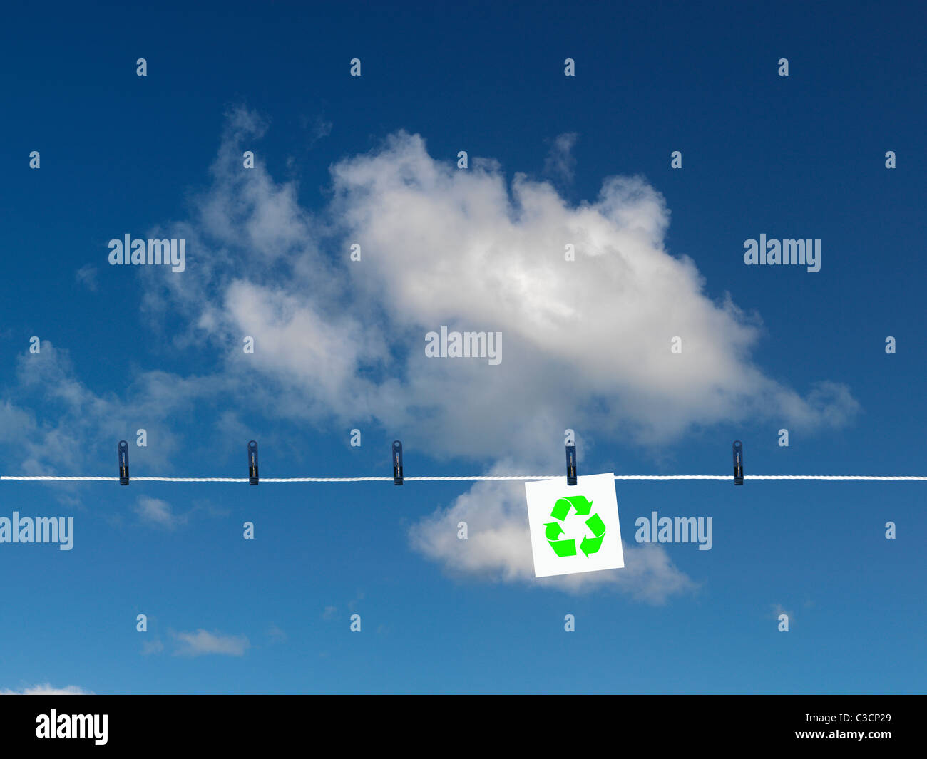 Un simbolo di riciclaggio su una linea di abbigliamento isolata contro un cielo blu Foto Stock