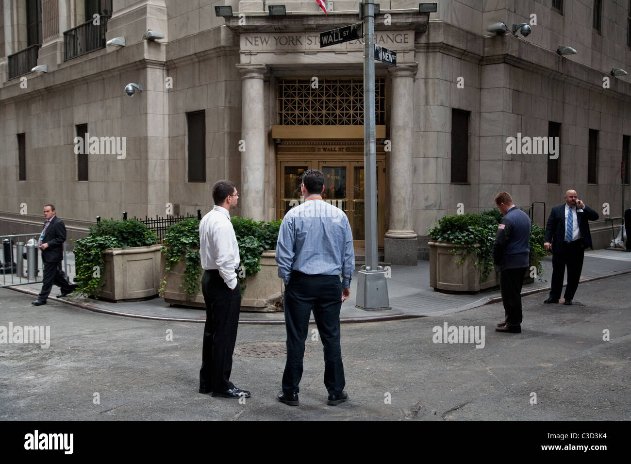 Gli operatori e le guardie di sicurezza al di fuori della Borsa di New York nel Quartiere Finanziario di New York, Stati Uniti d'America. Foto Stock