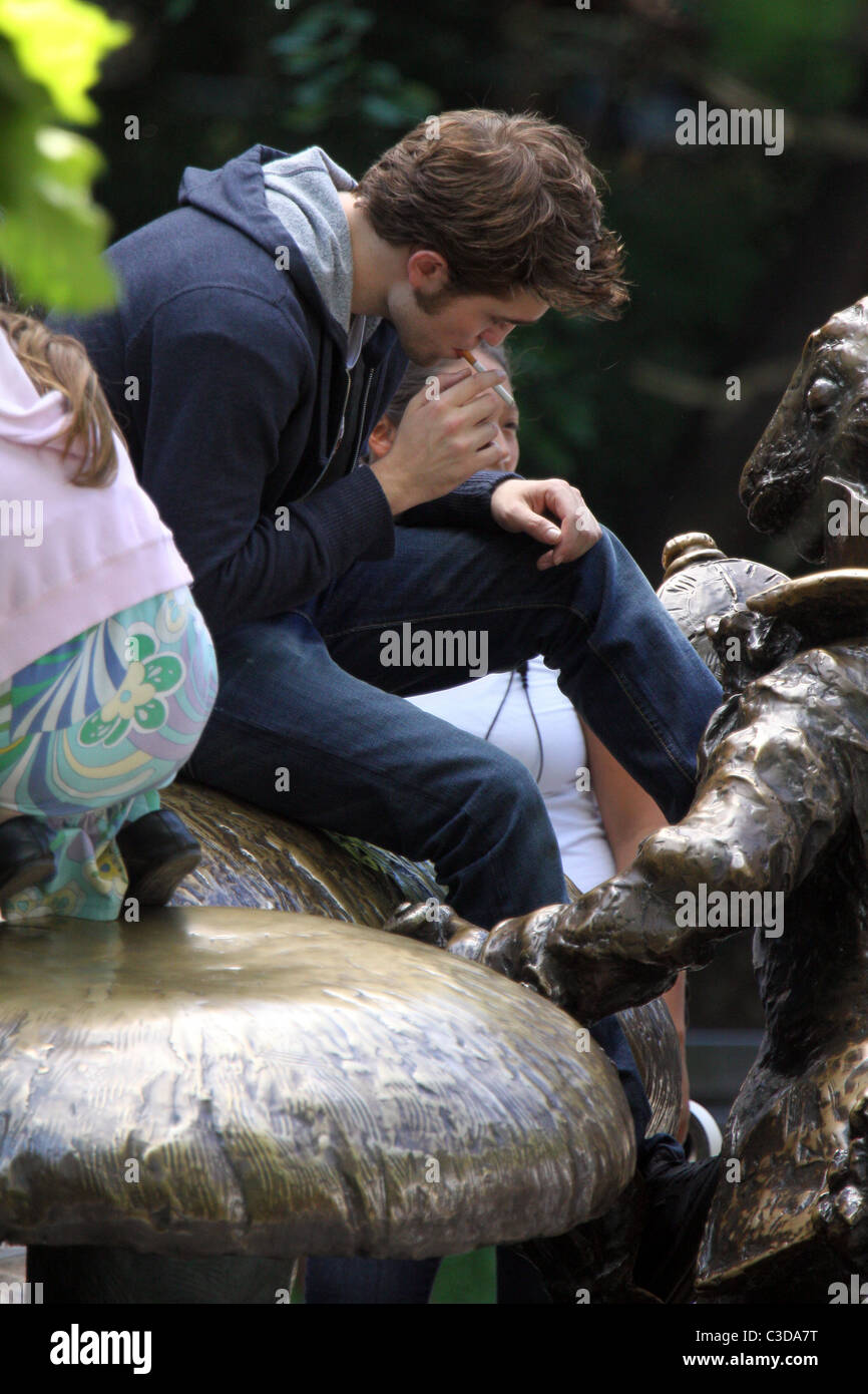 Robert Pattinson fuma una sigaretta sul set del suo nuovo film "Ricordami" durante la ripresa sulla posizione in un parco nel cuore di Manhattan. Foto Stock