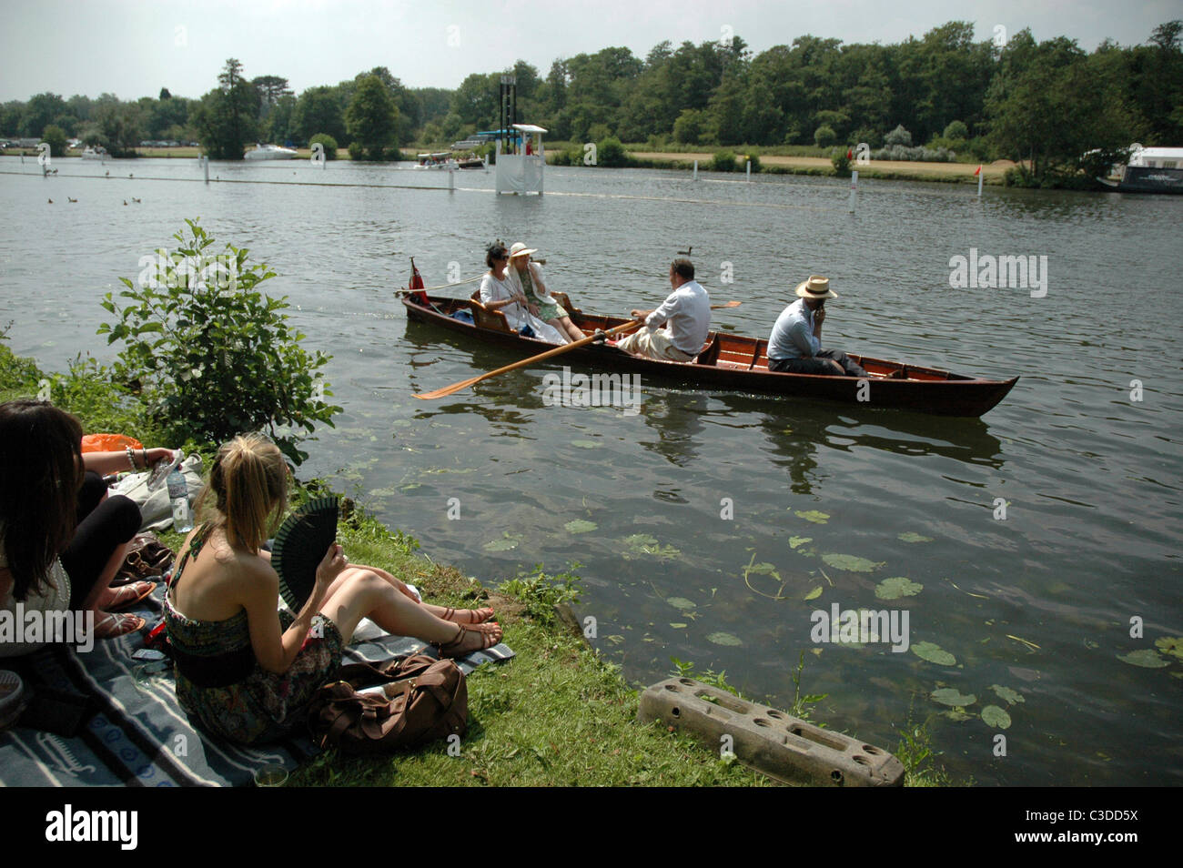 Atmosfera di spettatori seduti a lato del fiume e guardare la gara presso il Royal Henley Regatta. Oxfordshire, Inghilterra - 02.07.09 Foto Stock