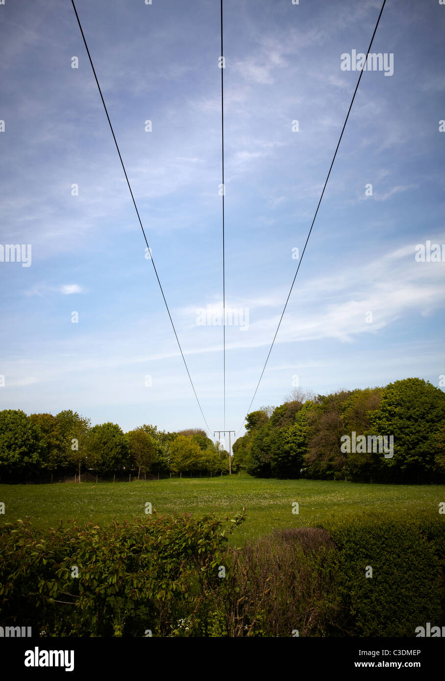 Pilone di elettricità. Pilone tiro dalla distanza contro il cielo blu brillante con cavi che corre verso il punto di osservazione in campagna Foto Stock