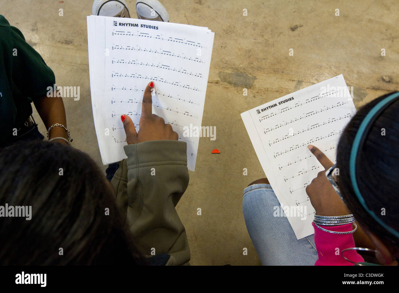 Gli studenti afroamericani seguire i testi musicali su carta durante la musica di classe ad una carta scuola elementare di Waco Texas USA Foto Stock
