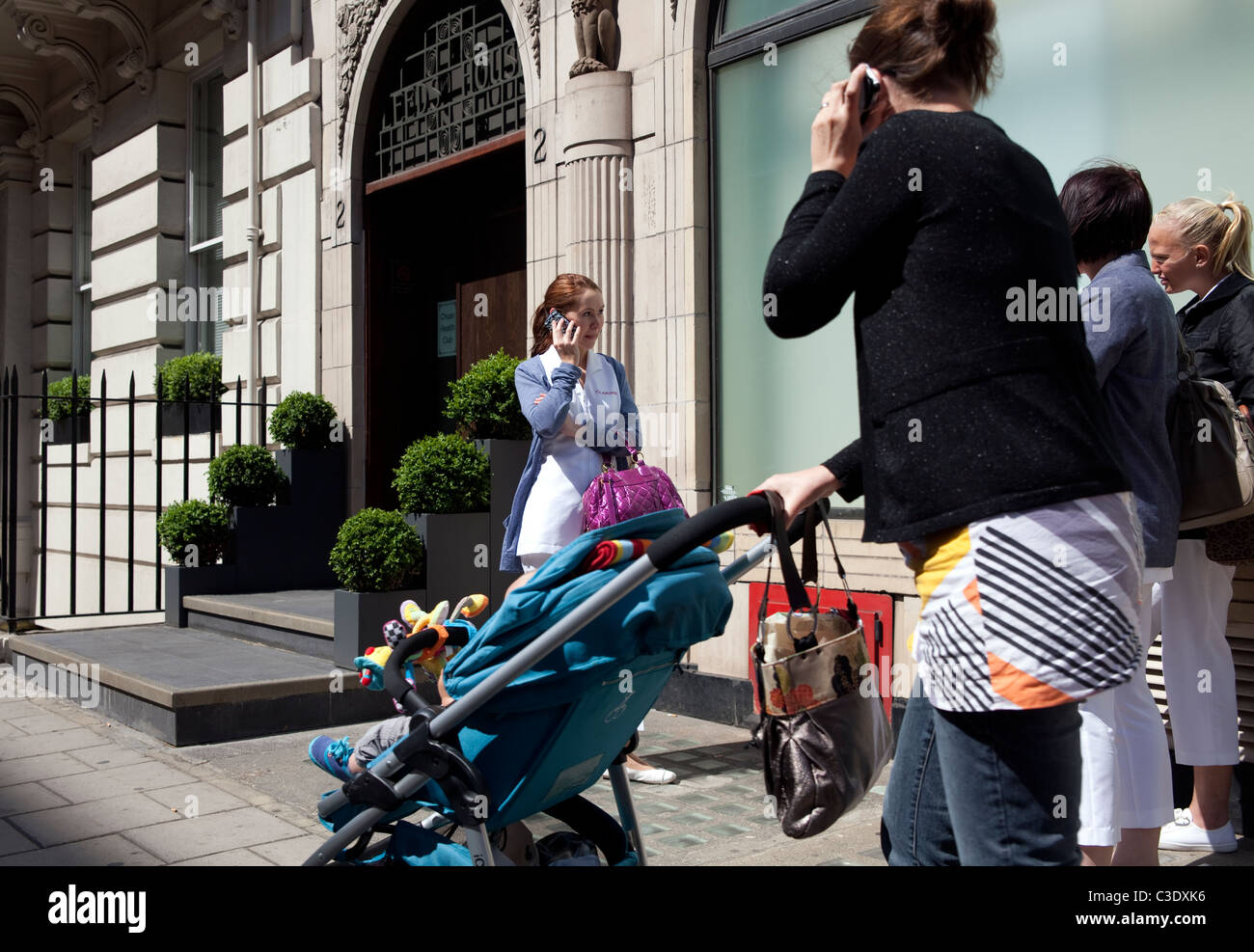 Oxford Street a Londra con le persone su telefoni cellulari Foto Stock
