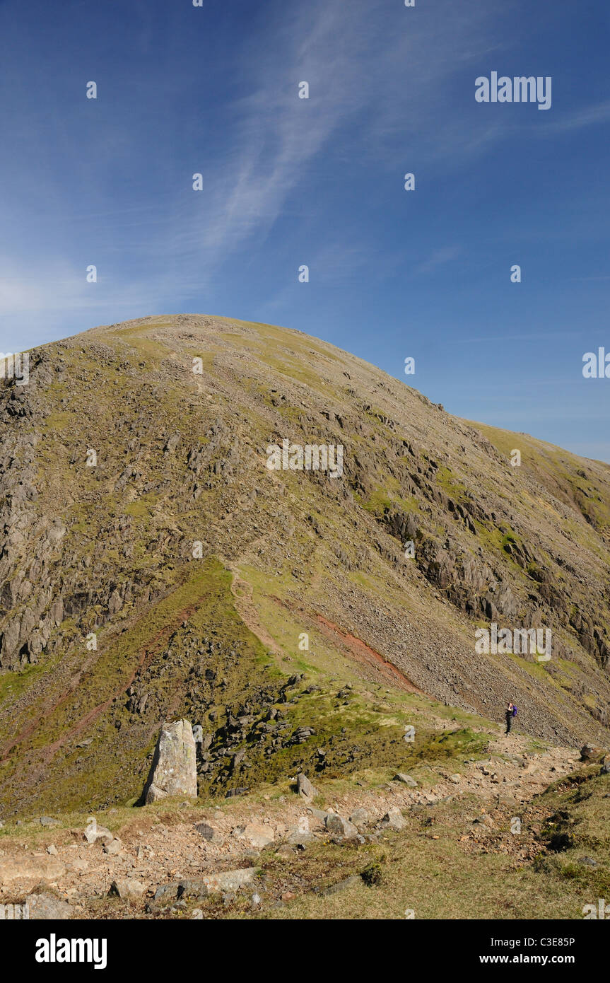 Walker vento di traslazione Gap, pilastro in background, Lake District inglese passeggiate in montagna Foto Stock