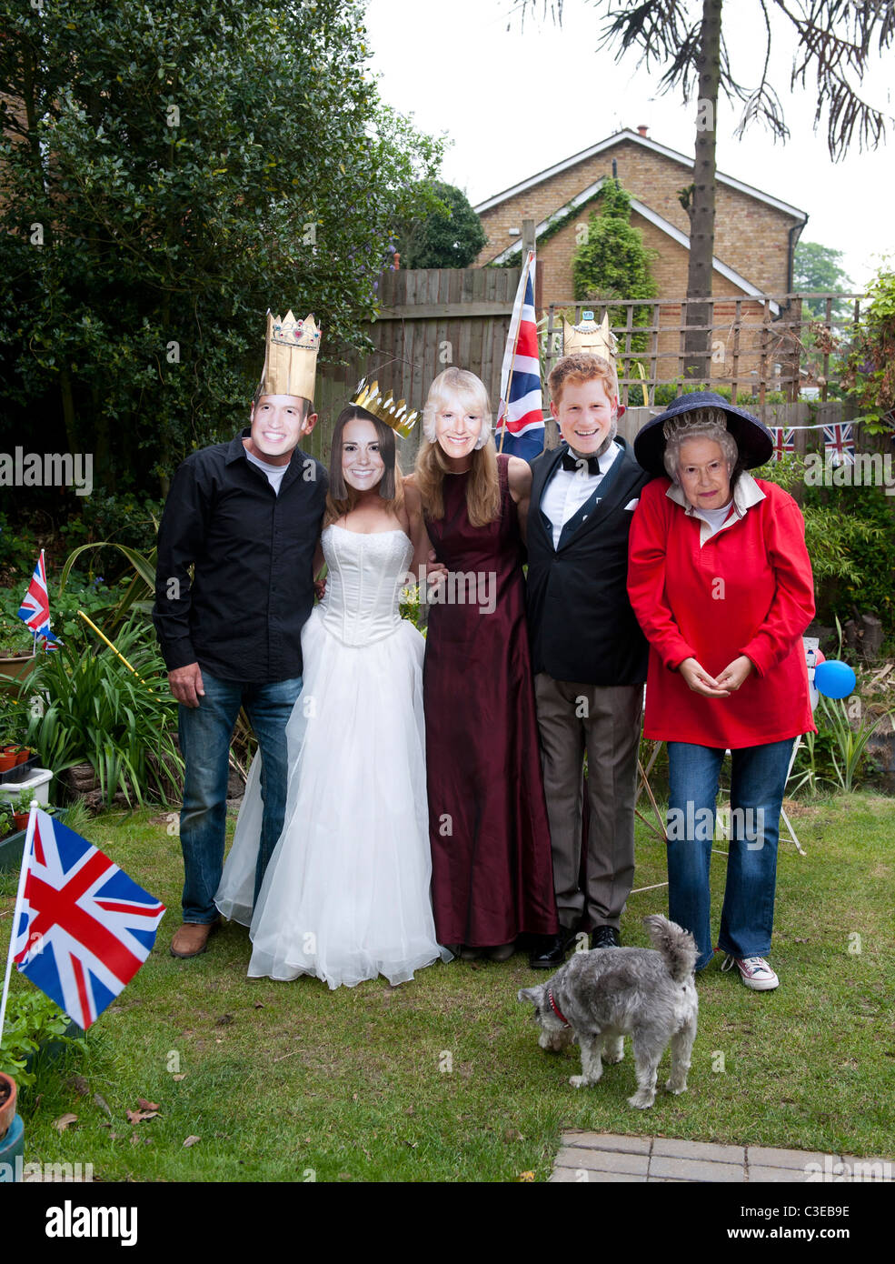 Royal Wedding street party feste in un giardino di Londra con i suoi ospiti indossando maschere Royal Foto Stock