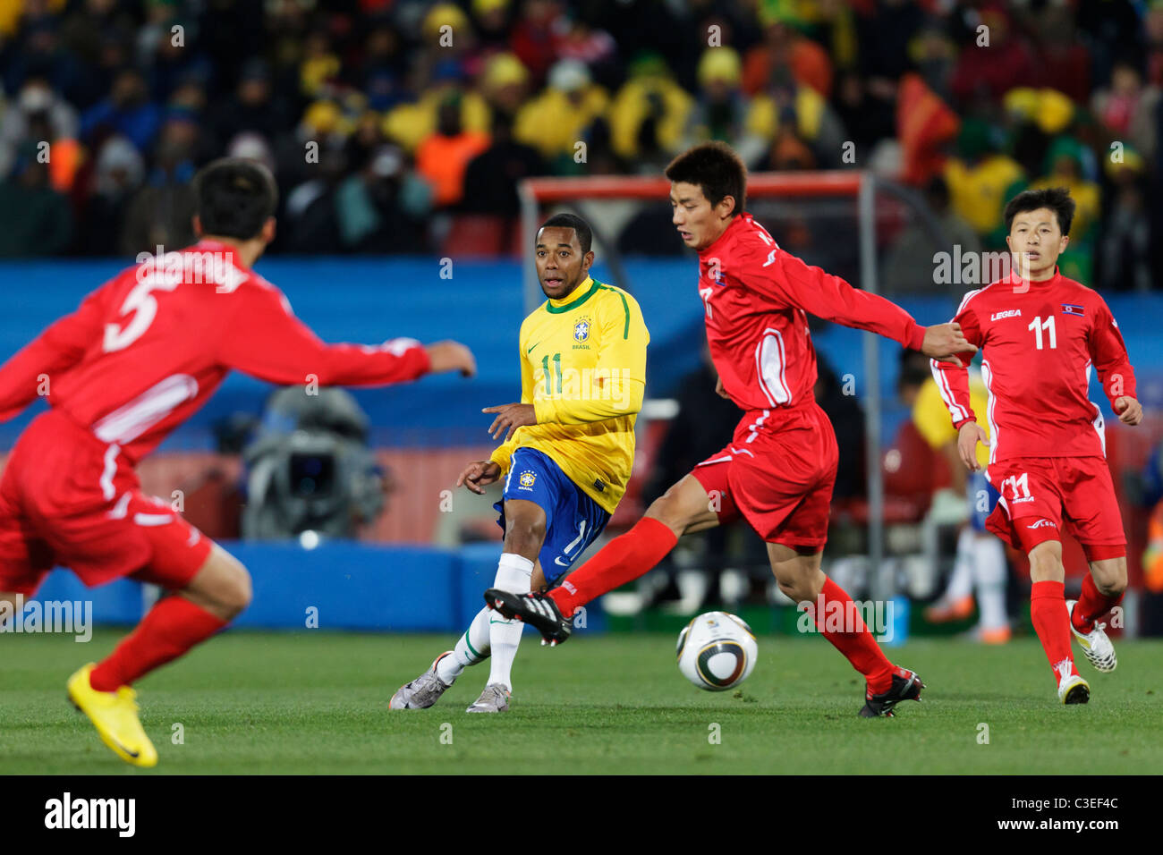 Robinho del Brasile passa la palla attraverso alla Corea del Nord la difesa durante una Coppa del Mondo FIFA Football Match Giugno 15, 2010. Foto Stock