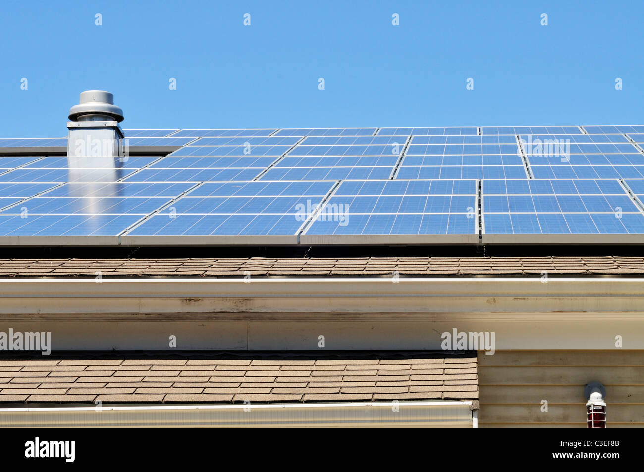 Pannelli solari sul tetto di un edificio su un soleggiato blue sky giorno Foto Stock