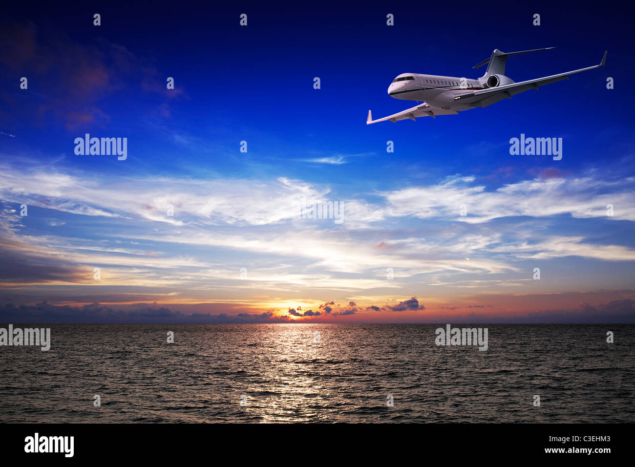 Luxury private jet oltre il mare al tramonto Foto Stock