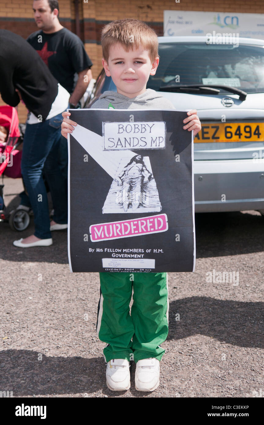 Ragazzo detiene un poster che sostiene di Bobby Sands è stato assassinato dal governo britannico Foto Stock
