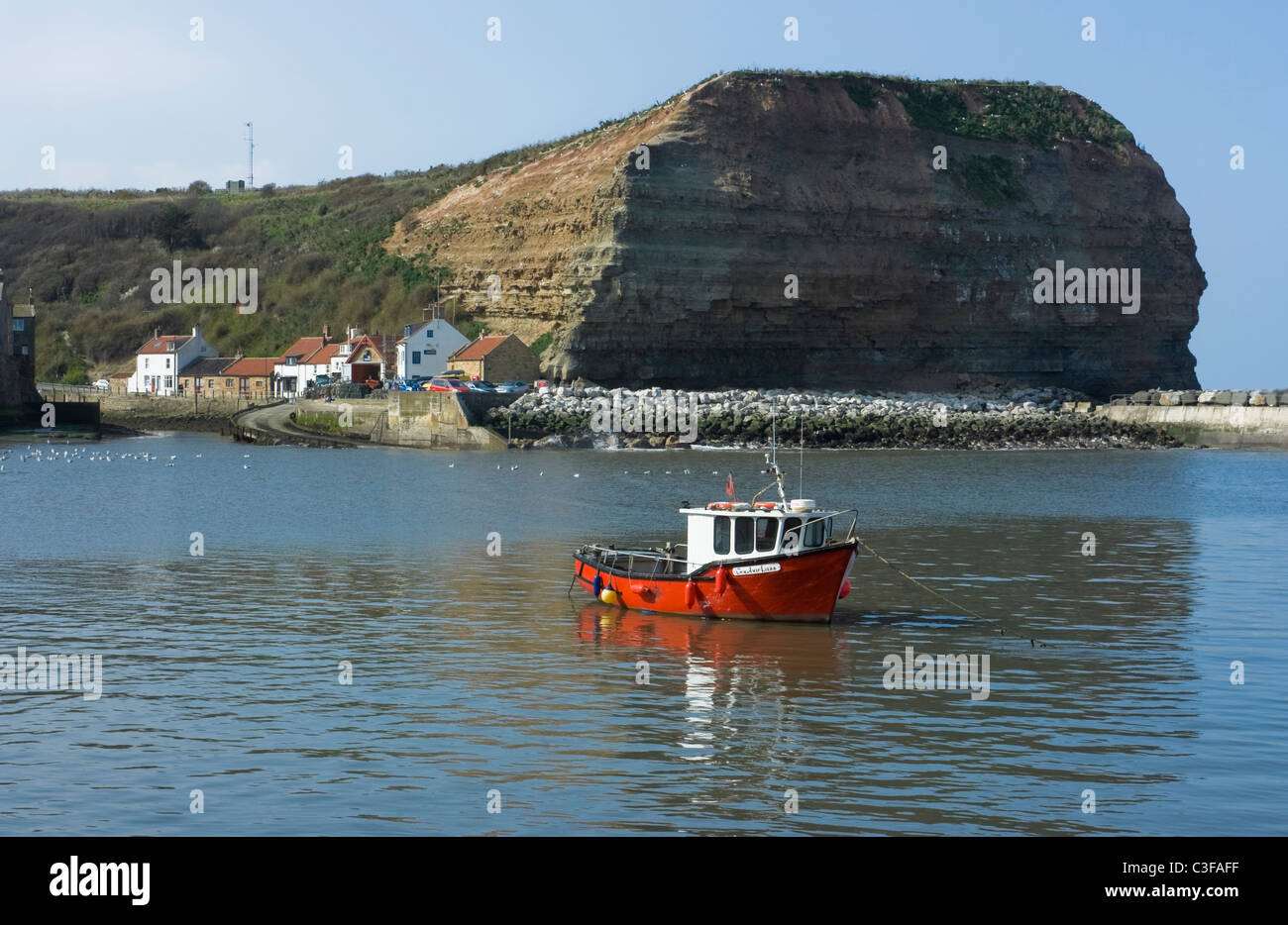 Una solitaria barca da pesca nel porto di Staithes North Yorkshire, Inghilterra Foto Stock