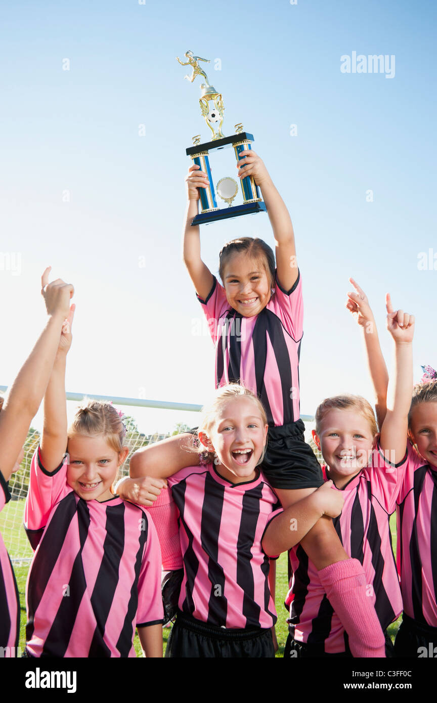 Il tifo girl i giocatori di calcio in posa con il trofeo Foto Stock