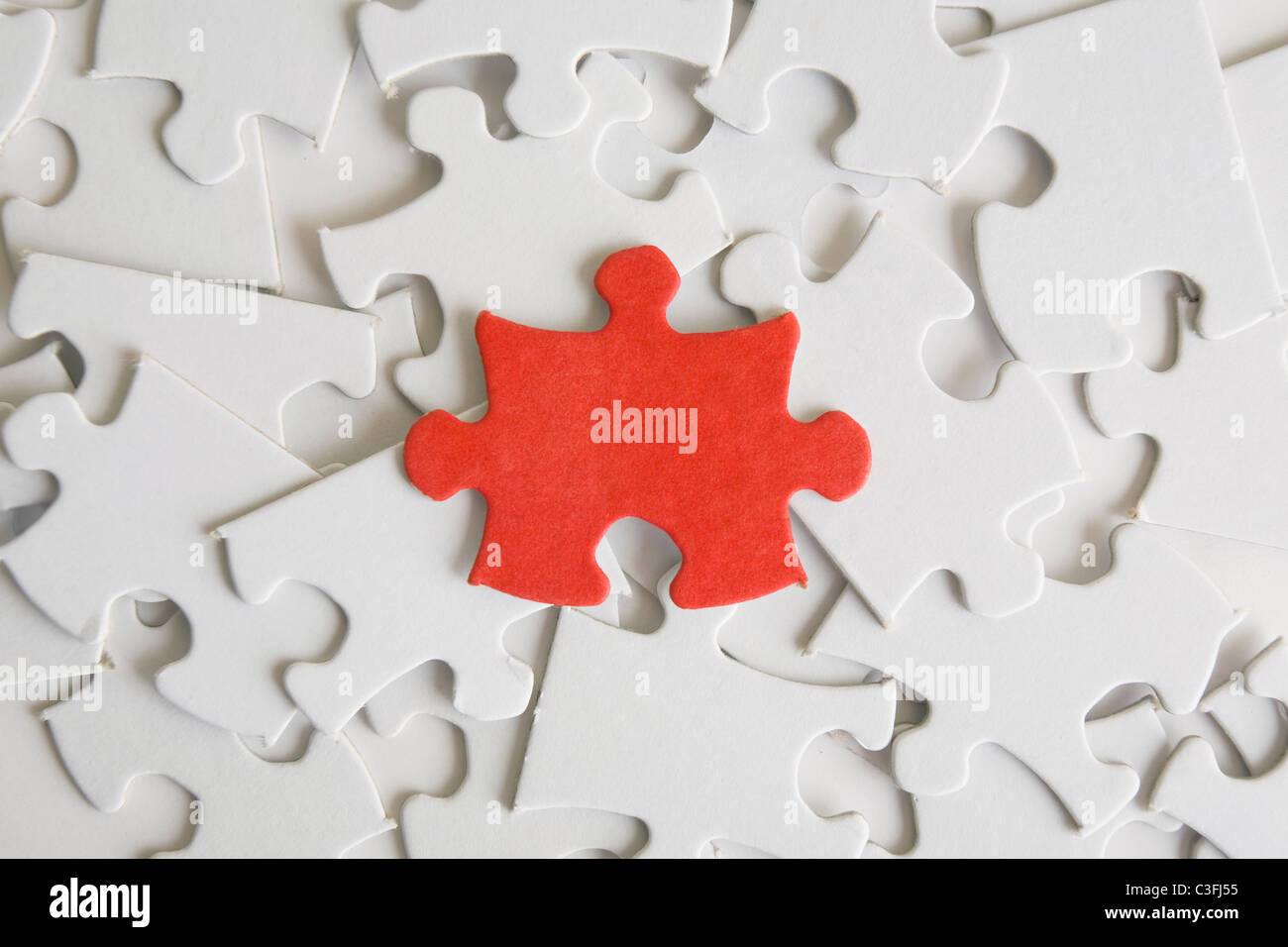Uno rosso pezzo del puzzle su un pìle di quelli vuoti. Foto Stock