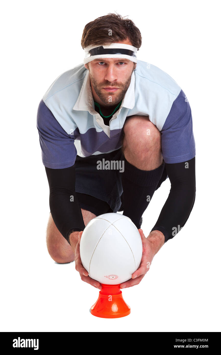Foto di un giocatore di rugby posizionando la palla su un kicking tee, ritagliata su uno sfondo bianco. Foto Stock