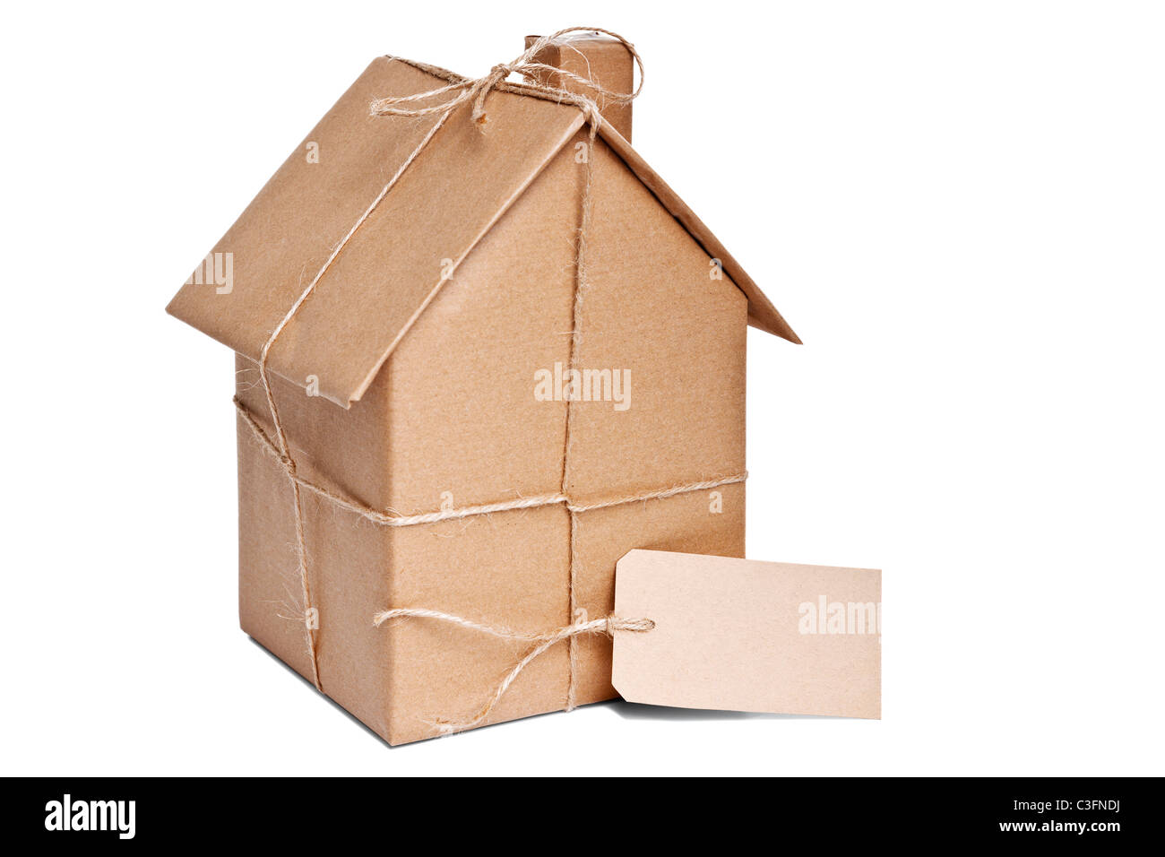 Foto di una casa avvolta in carta riciclata marrone con etichetta, ritagliata su uno sfondo bianco. Foto Stock