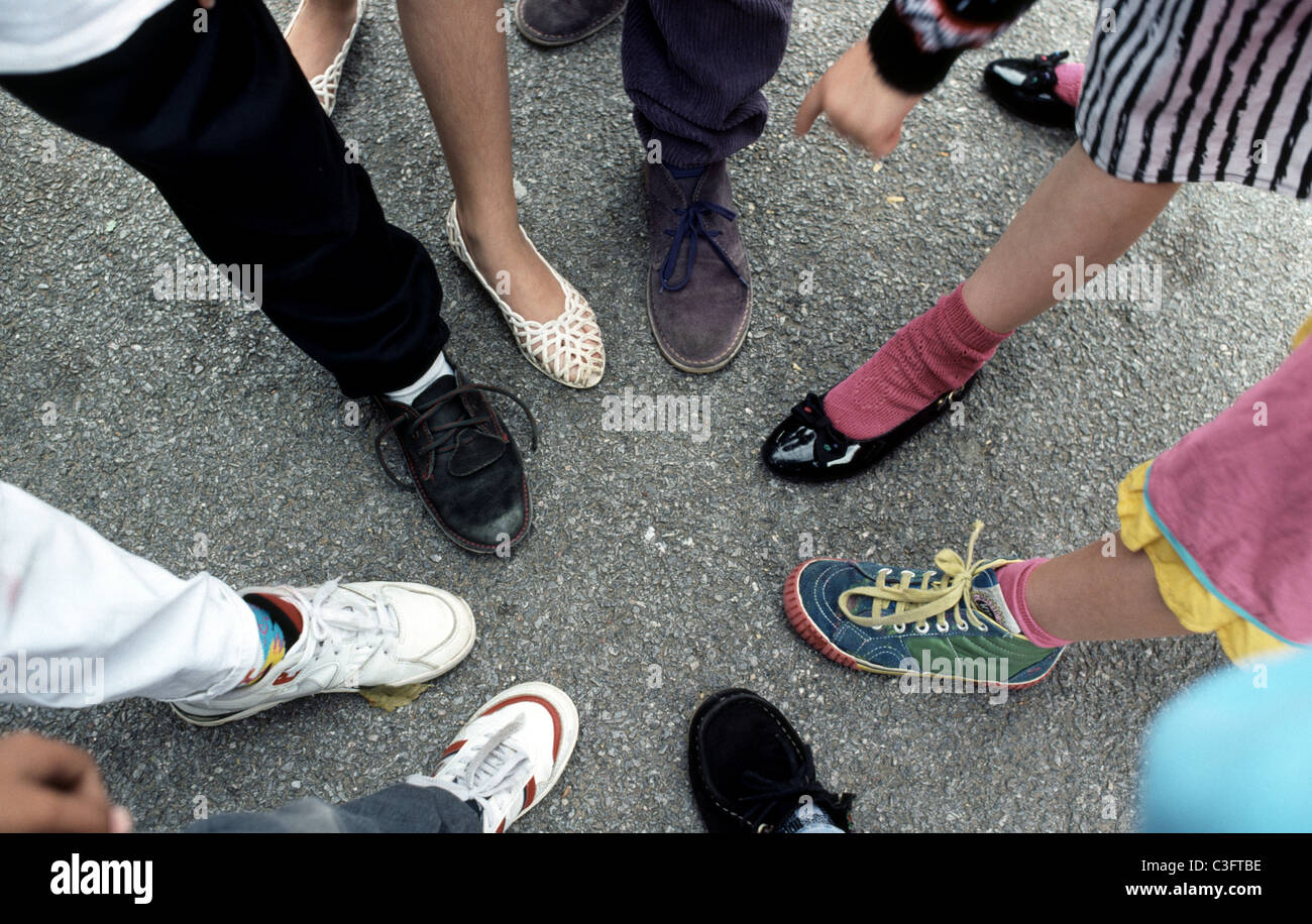 I bambini di un piede in avanti in un cerchio che mostra vari calzature Foto Stock