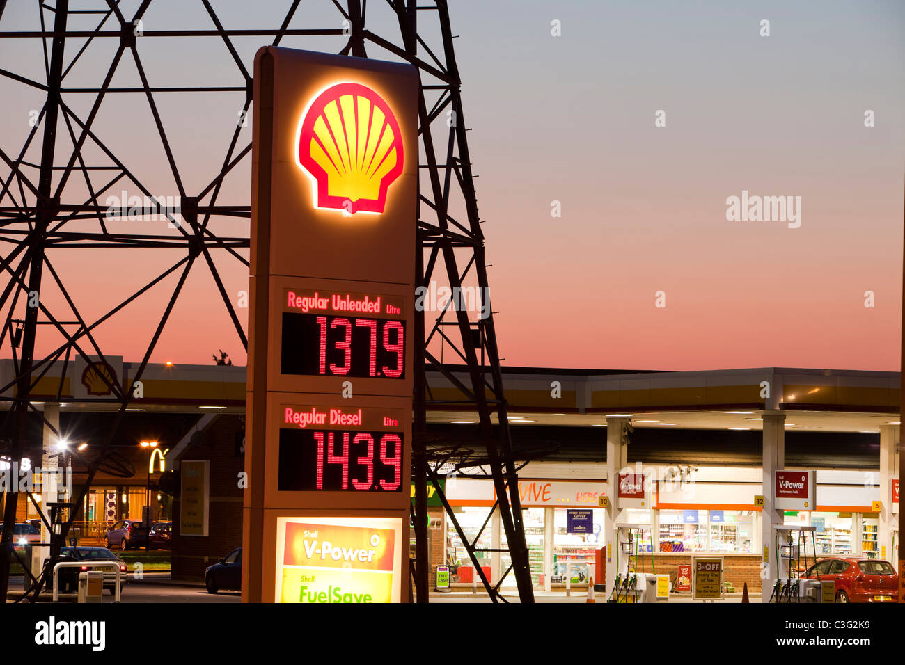 Una benzina sation in Billingham su Teeside, Regno Unito, con un traliccio di elettricità al crepuscolo. Foto Stock