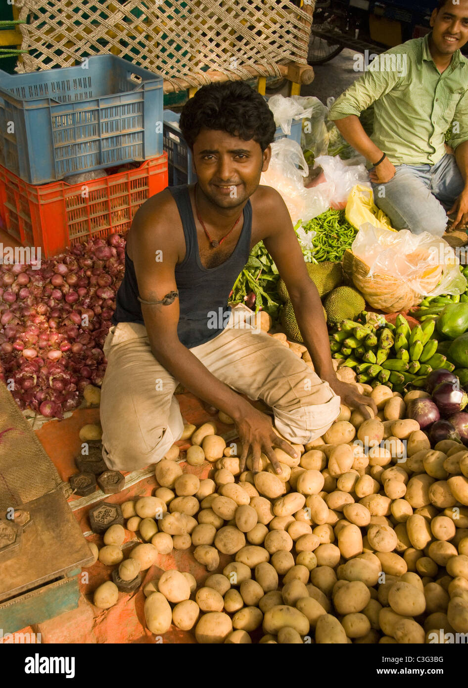 Ritratto di un uomo vendere verdure a un mercato in stallo, Chandni Chowk, Delhi, India Foto Stock