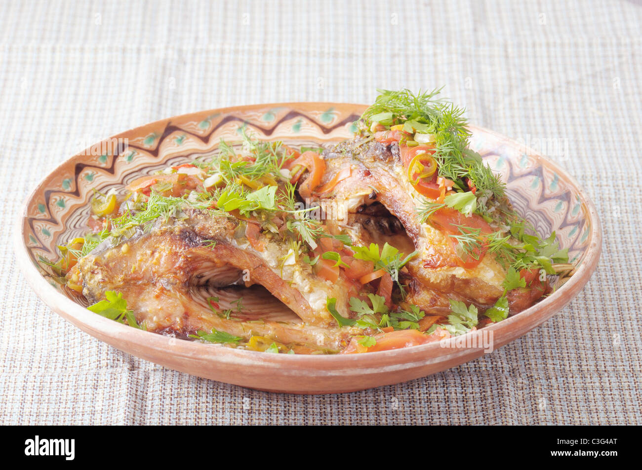 Tradizionale rumena cibo fatto da grigliate di pesce sul sale e coperto con salsa piccante Foto Stock
