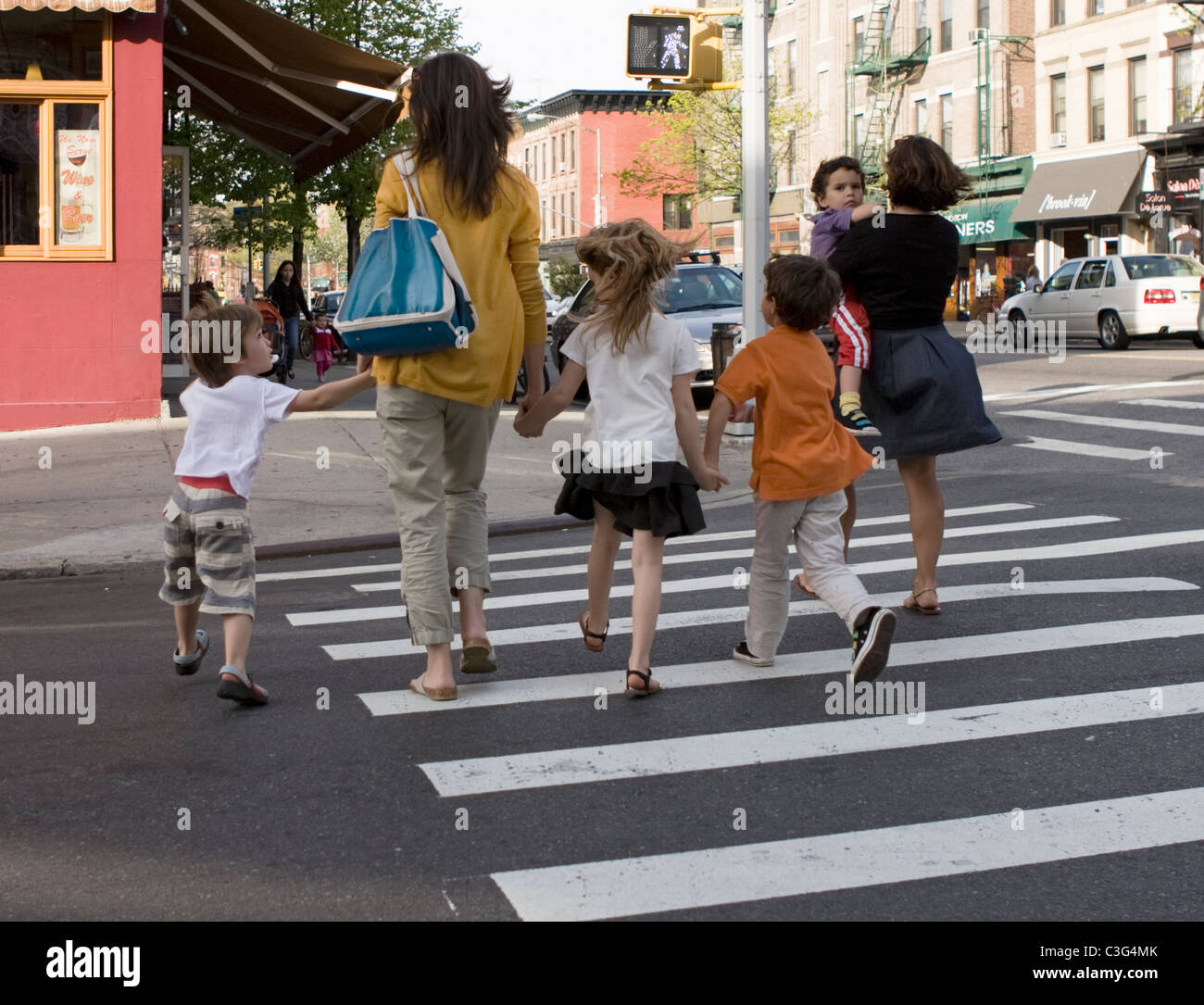 I bambini tenere mani mentre attraversa una strada di Brooklyn, New York. Foto Stock