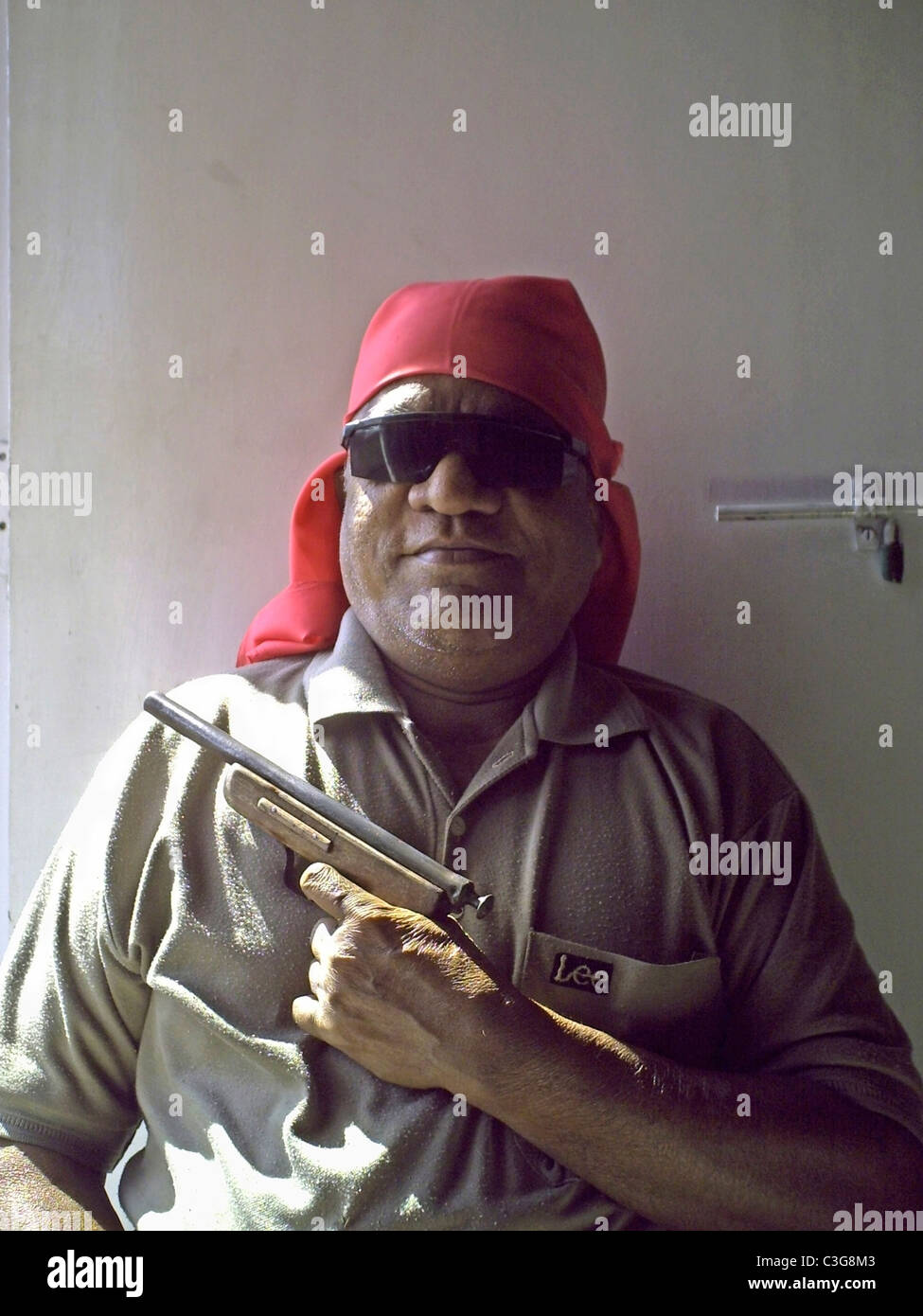 Un vecchio uomo è con il nero goggle, il tappo e la pistola in mano Foto Stock