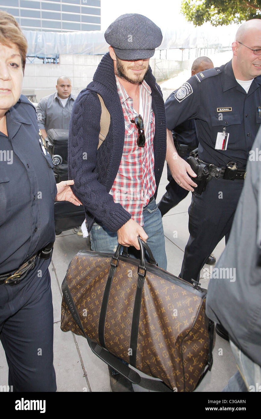 David Beckham, portando il suo Louis Vuitton borsa da viaggio, ottiene una  scorta della polizia come egli arriva al LAX Airport su un British Airways  Foto stock - Alamy