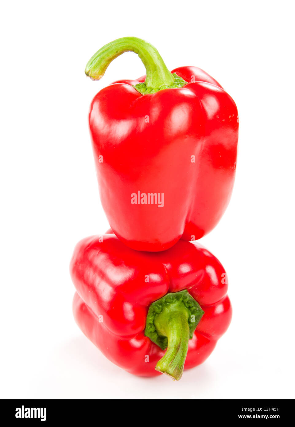 Due freschi peperoni rosso su bianco Foto Stock