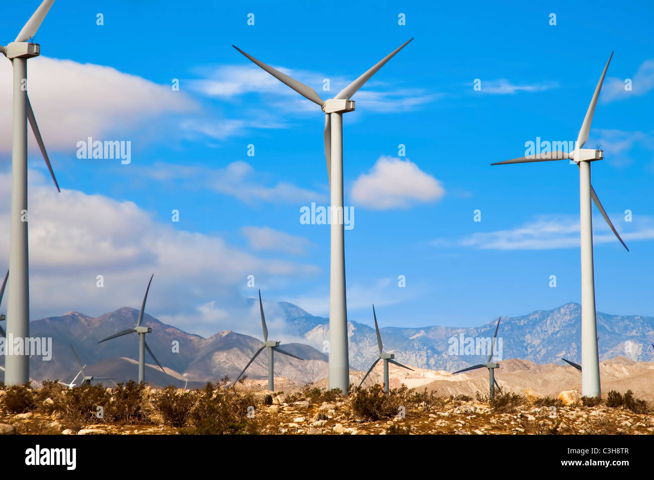 Le turbine eoliche in un ambientazione desertica con le montagne sullo sfondo Foto Stock