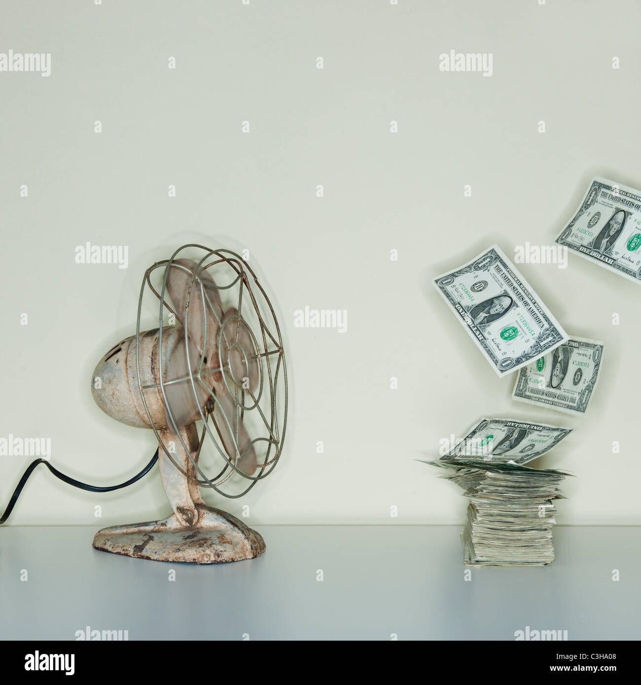Ventola elettrica che soffia sul mucchio di banconote di dollari Foto Stock