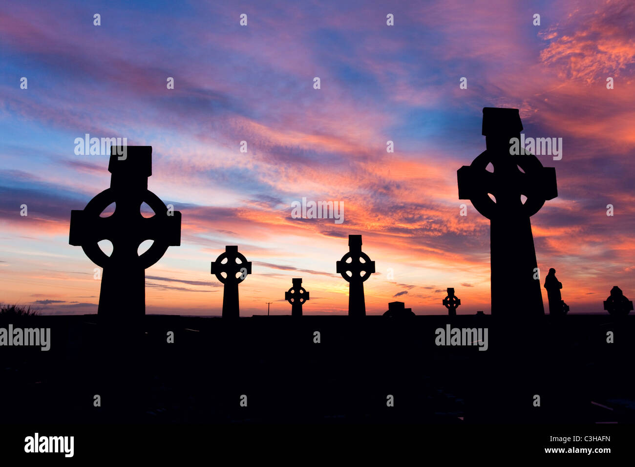 Croci celtiche in un cimitero al tramonto, Enniscrone, nella contea di Sligo, Irlanda. Foto Stock