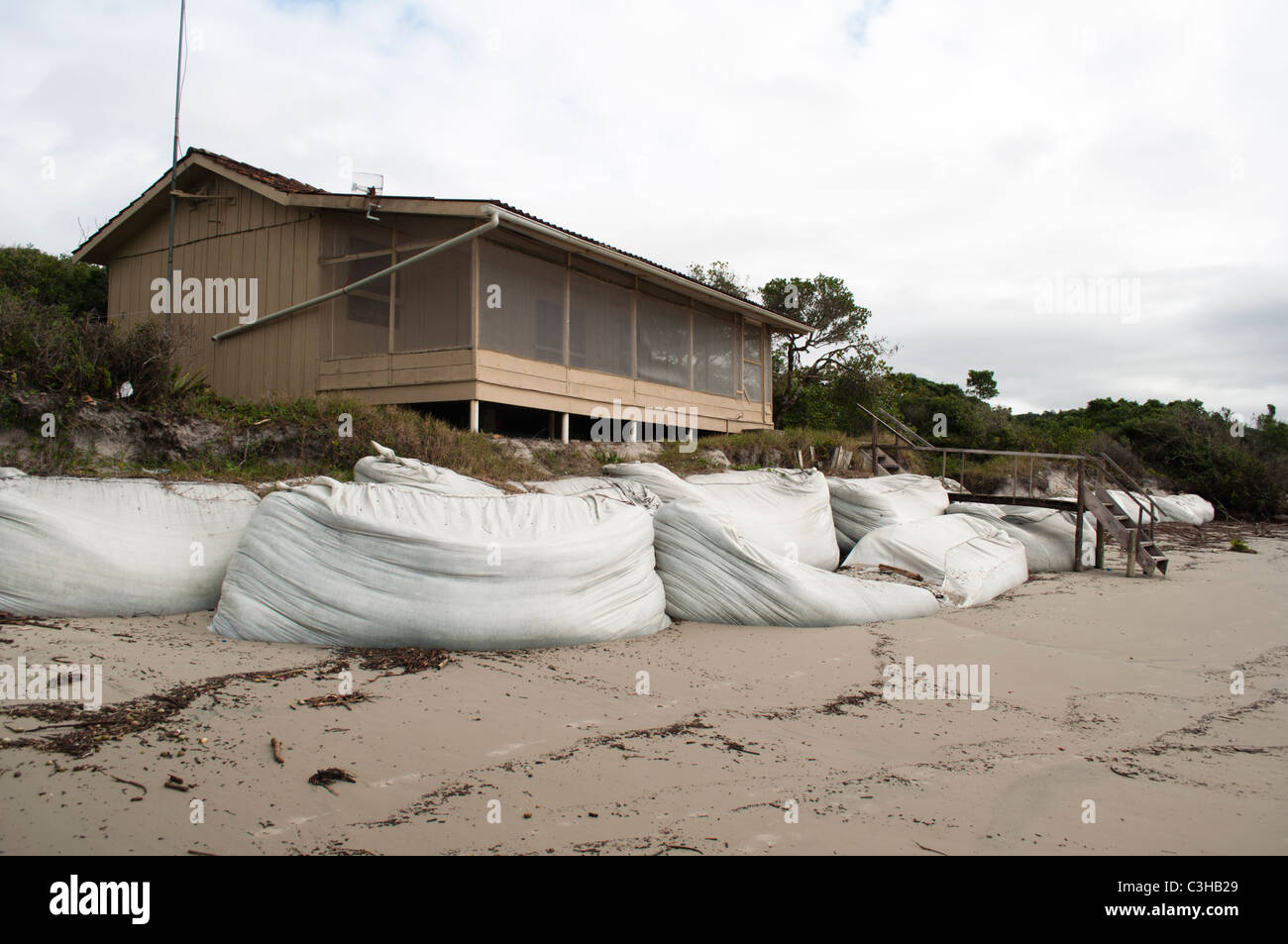 Barriera di sacchetti di sabbia cercando di smettere di livello del mare aumentando in Ilha do Mel, Paraná, Brasile. Foto Stock