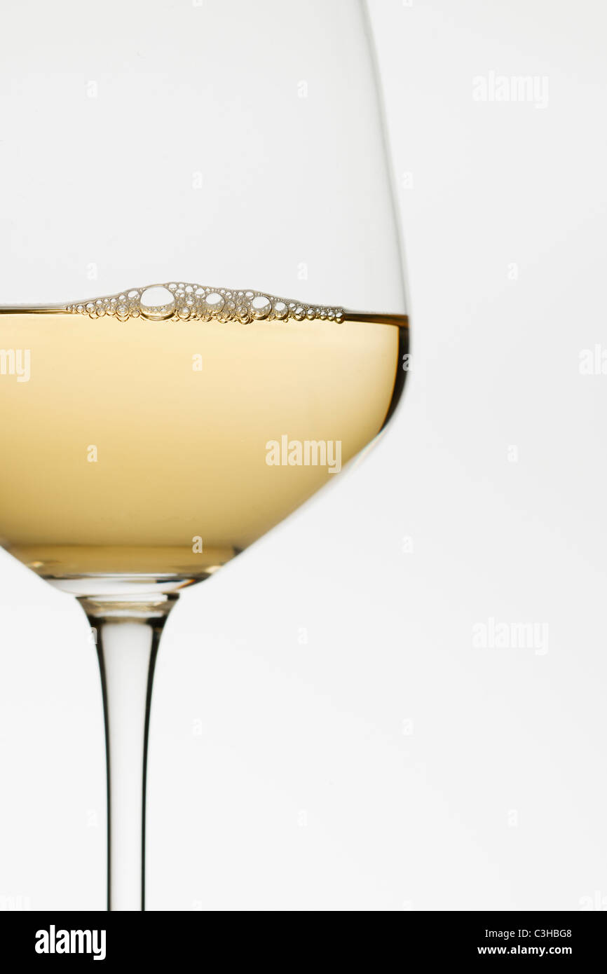 Chiusura del bicchiere di vino bianco su sfondo bianco Foto Stock