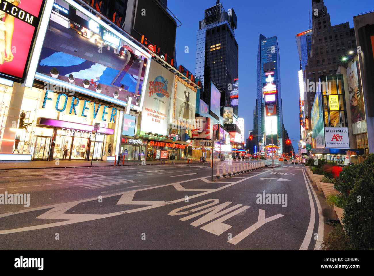 Vetrine e annunci pubblicitari in un insolitamente deserta Times Square a New York City all'alba. Foto Stock