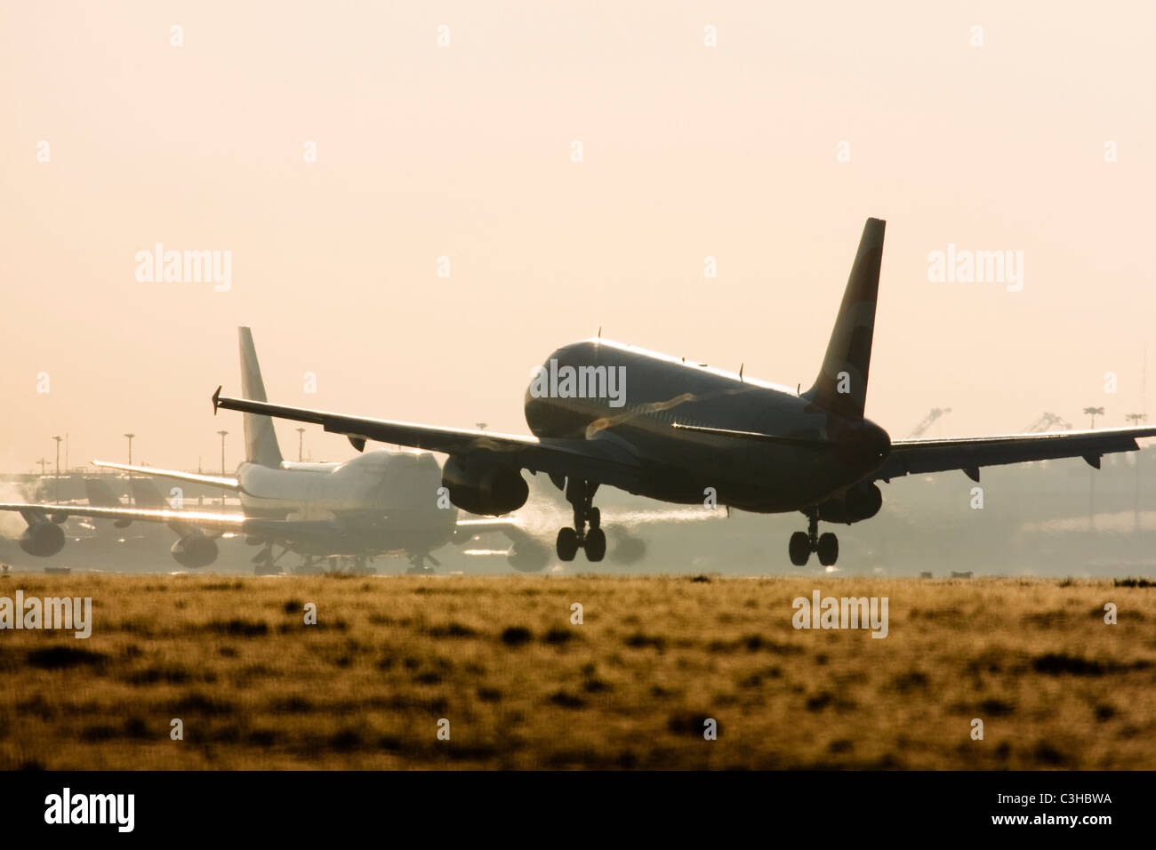 Aereo commerciale in atterraggio a Londra Heathrow con le scie di condensazione formando al di sopra di dette alette. Foto Stock